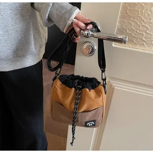 Gedetailleerd overzicht van een casual bruine nylon bucket bag met trekkoord