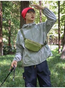 Man wearing a stylish green textured outdoor waist bag in a forest for hiking trips.