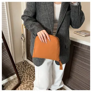 Detail view of the orange travel pouch showing its zipper and compact fabric design.