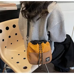 Lifestyle detail van een gele en bruine nylon schoudertas met handig trekkoord