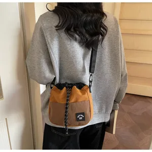 Casual nylon emmer tas met trekkoord in kleurvlakken gedragen door een model achter