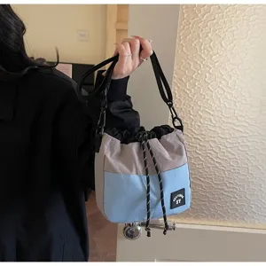Casual nylon bucketbag met trekkoord in een lichtgrijs en blauw kleurblokontwerp.