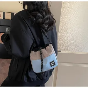 Detail van een blauw en grijze nylon bucket bag met handige trekkoordsluiting.