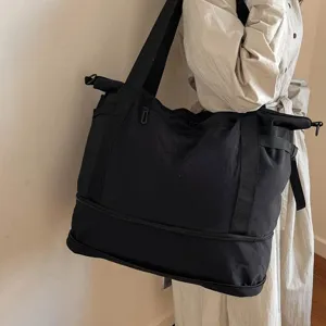 Large capacity black travel duffel bag for women, lightweight commuting shoulder bag.
