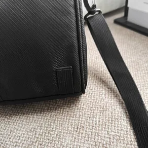 Close-up detail van de duurzame zwarte ballistische nylon textuur op deze casual schoudertas