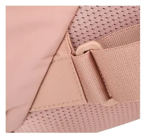 Close-up view of a pink nylon backpack strap connection and breathable mesh back panel.