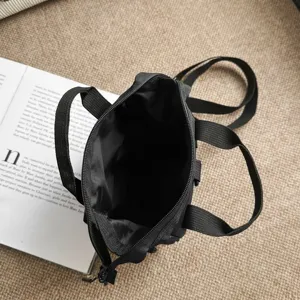 Detailopname van de binnenruimte van een zwarte nylon multifunctionele schoudertas