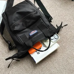 Detailoverzicht van zwarte nylon crossbodytas die de opslagcapaciteit laat zien.