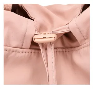 Detailed close-up showing the pink nylon fabric and drawstring buckle of travel backpack