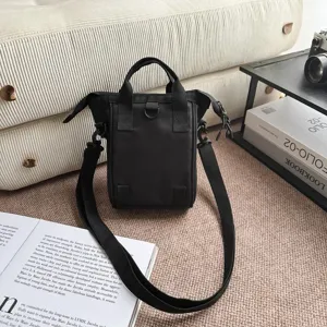 Detailweergave van zwarte nylon crossbody telefoontas met riem in lifestyle setting.