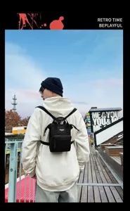 Veelzijdige kleine zwarte crossbody rugzak voor heren en dames tijdens een casual stadswandeling