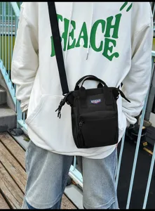Close-up van een trendy zwarte canvas crossbody telefoontas voor dagelijks gebruik