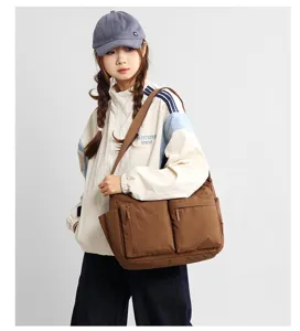 Large brown multi-pocket messenger bag shown on model for Japanese casual workwear style
