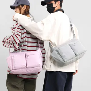 Close-up detail of casual multi-pocket messenger bags in light purple and grey colors