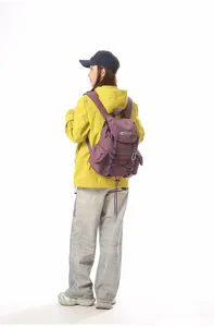 Detailansicht des lila Wanderrucksacks, getragen von einem Modell in gelber Jacke