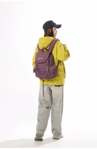 Rückansicht einer Frau mit einem violetten Wanderrucksack in einem hellen Fotostudio