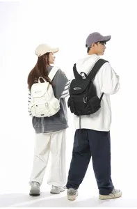 Männliche und weibliche Models präsentieren schwarz-weiße leichte Outdoor-Wanderrucksäcke