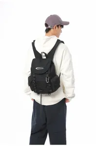 Ein männliches Model trägt einen großen schwarzen Outdoor-Wanderrucksack auf weißem Grund