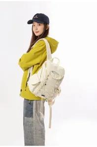 Modell trägt den cremeweißen Wanderrucksack vor einem sauberen Studiohintergrund