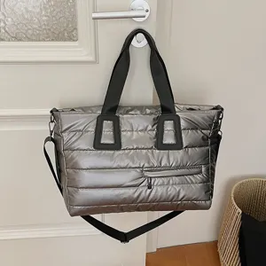 Stylish metallic silver quilted tote bag with large capacity and soft padded handle.
