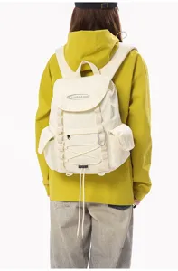 Detaillierte Rückansicht eines cremefarbenen Wanderrucksacks an Modell in gelber Jacke