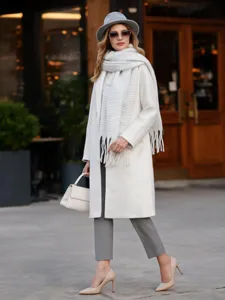 Dettaglio di una sciarpa bianca spessa in finto mohair con seta lucida e frange.