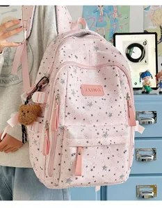 Dettaglio dello zaino rosa con motivo a stelle, tasche con zip e ciondolo a orsetto