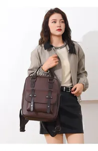 Nahaufnahme eines braunen Vintage-Lederrucksacks, gehalten von einem stilvollen Model.