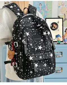 Vista laterale dettagliata dello zaino scolastico nero con stelle e ciondolo a orso