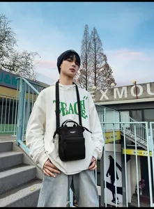 Stijlvolle zwarte crossbodytas voor heren gedragen in een stoere stedelijke omgeving.