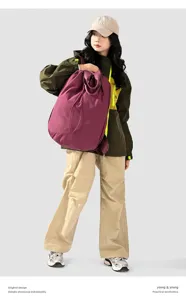 Fashionable large capacity burgundy nylon backpack shown with casual outdoor outfit on model