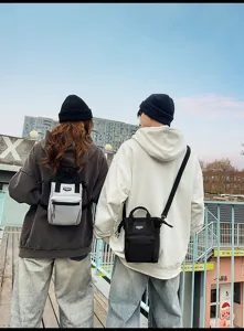 Buitenstijlweergave van stijlvolle kleine crossbodytassen voor heren en dames in grijs.