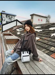 Stijlvolle witte mini crossbodytas gedragen door een model in een stad