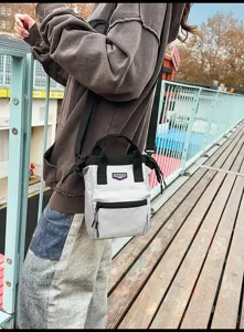 Casual grijze canvas mini crossbody tas voor buiten met een functionele ritszak aan de voorkant