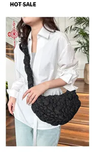 Casual style black quilted bubble cloud bag shown on model wearing white shirt and jeans