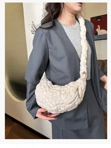 White bubble quilted cloud bag worn by a model, showing puffy texture and crescent shape