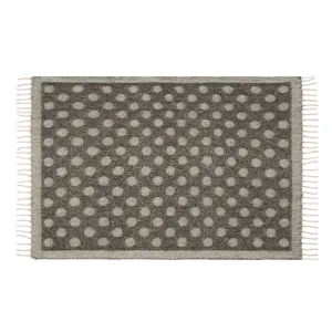 Gros plan sur le motif jacquard à pois et la texture douce en fil bouclé avec franges