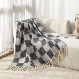 Detailed view of the grey and white checkered mohair style blanket with tassels