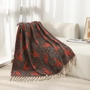 Detalle de manta jacquard con estampado de pata de gallo y borlas decorativas