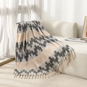 Close-up of faux mohair ethnic jacquard throw blanket with decorative tassels on sofa