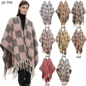 Vue détaillée de la texture douce du mohair et des divers motifs à carreaux du poncho