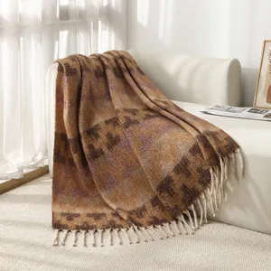 Detail of a faux mohair throw blanket with ethnic patterns and decorative fringe.
