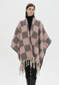 Vue rapprochée montrant la texture douce en mohair et les franges d'un poncho rose