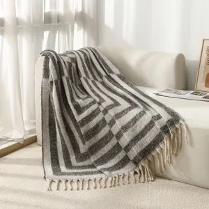 Detailansicht der nordischen geometrischen Wohndecke mit Stricktextur und Fransen