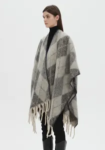 Vista dettagliata di uno scialle jacquard spesso con frange in morbido filato bouclé.