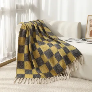 Cozy mohair-like checkered throw blanket with decorative tassels on a modern white sofa