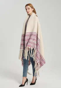 Model wearing a thick bouclé yarn shawl blanket featuring stripes and long fringe details