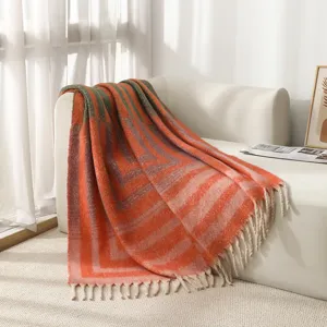 Detailaufnahme der nordischen geometrischen Jacquard-Wohndecke mit Fransen auf weißem Sofa