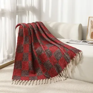 Close-up of red and grey checkered plaid boucle throw blanket with decorative tassels