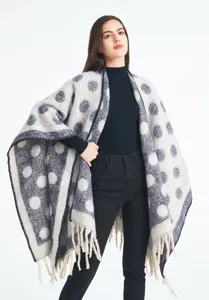 Detalle de la textura gruesa de hilo bouclé y diseño jacquard de lunares en el chal